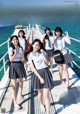 A group of young women standing on top of a pier.