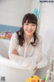 A woman sitting in a bathtub with a rubber duck.