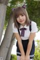 A young woman in a school uniform posing for a picture.