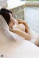 A woman in a wedding dress laying on a bed.